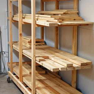 以下が含まれることがあります： 4 つの車輪が付いた木製の手押し車。木材の板を保管および輸送するために使用されます。手押し車は 4 つの棚があり、それぞれにさまざまなサイズの板が置かれています。