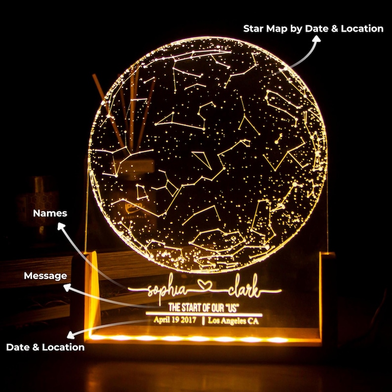 Puede incluir: Una luz nocturna de mapa de estrellas personalizada con una base de acr&iacute;lico transparente y una esfera redonda iluminada. La esfera muestra las constelaciones visibles el 19 de abril de 2017 en Los &Aacute;ngeles, California. La base est&aacute; grabada con los nombres "sophia" y "clark" y el texto "THE START OF OUR "US"".