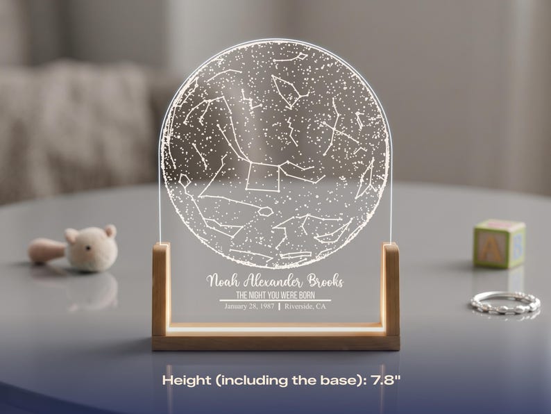 May include: A personalized night sky map, 7.8 inches tall, with a wooden base. The clear acrylic panel displays a constellation design and the text "Noah Alexander Brooks, The Night You Were Born, January 28, 1987, Riverside, CA."