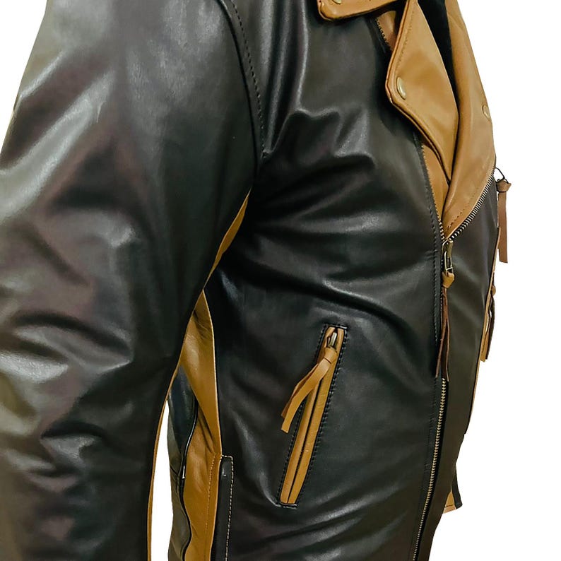 May include: A black and brown leather jacket with a zipper closure and a contrasting brown panel on the side. The jacket has a zippered pocket on the left side.
