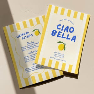 Puede incluir: Dos tarjetas de invitaci&oacute;n con un borde a rayas amarillas y blancas e ilustraciones de limones. Una tarjeta dice "CIAO BELLA" en azul, y la otra dice "WEEKEND DETAILS" en azul. Las tarjetas tienen detalles del evento.
