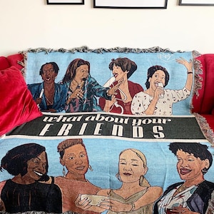 May include: A woven tapestry throw blanket featuring a group of six women of color. The blanket is blue with a black border and the text "what about your FRIENDS" in white.