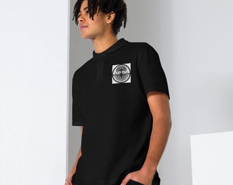 Op de afbeelding: Een zwart poloshirt met een wit logo met een boom met wortels en de tekst "GRO WTH".