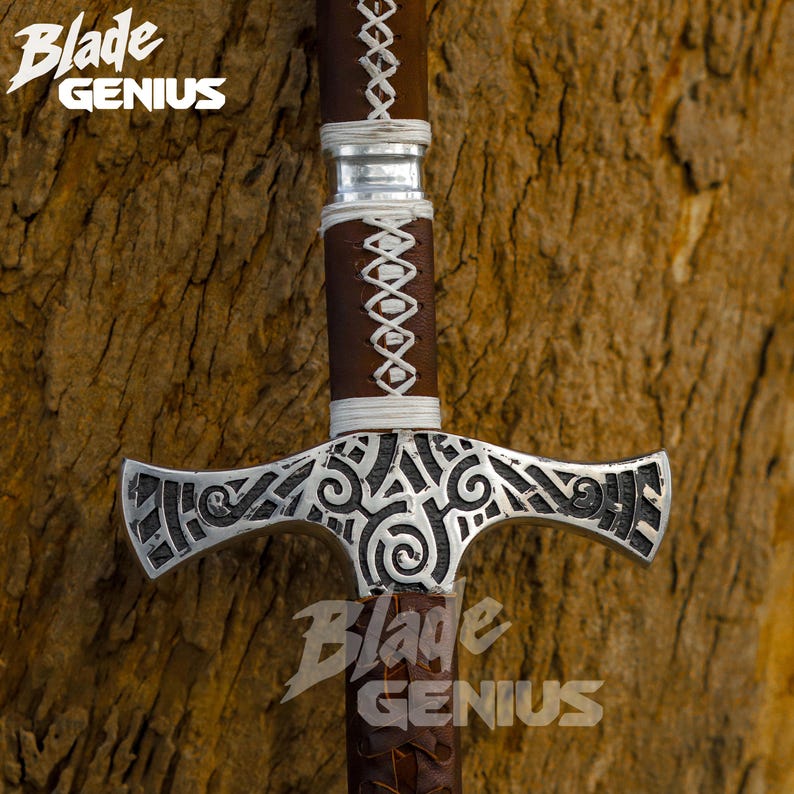 Pu&ograve; includere: Primo piano di una spada argentata con un manico in pelle marrone e intagli intricati sulla lama. La spada &egrave; su uno sfondo di legno con il testo "Blade Genius" sul manico.