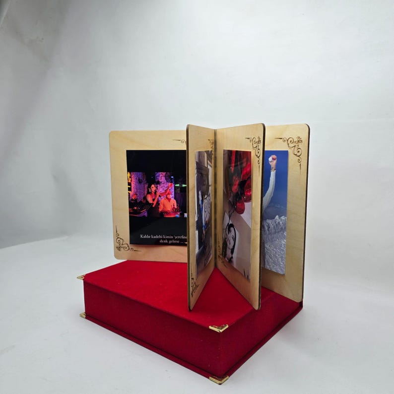 May include: A wooden photo frame with four slots for displaying pictures. The frame is decorated with a gold-coloured design and sits on a red velvet base.