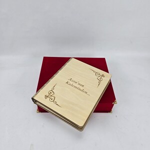 May include: A wooden book with a red velvet box. The book has the text "Azra'nun Kaleminden..." engraved on the cover.