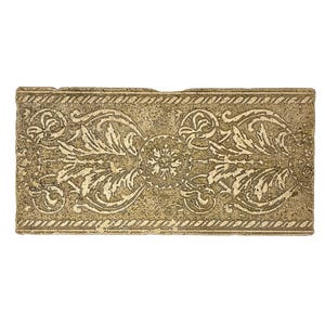 May include: Rectangular, antique-style decorative piece with a textured, aged appearance. The surface is a muted gold color, adorned with a repeating floral and scrollwork pattern in a lighter, off-white hue. The edges feature a rope-like border.