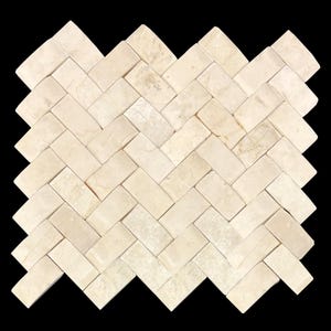 May include: A close-up of a herringbone pattern tile mosaic. The tiles are rectangular and have a light beige color with subtle variations. The pattern is set against a black background, highlighting the texture and design of the tiles.