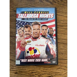 Peut inclure: Un boîtier DVD du film Talladega Nights: The Ballad of Ricky Bobby, montrant Will Ferrell et d'autres acteurs en combinaisons de course devant un drapeau américain. La jaquette inclut le texte BEST MOVIE EVER MADE.