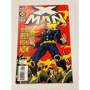 May include: X-Men comic book featuring a character in a blue and yellow costume against a red and yellow background. The cover reads "X-Man" and "The Age of Apocalypse Begins Now!" with the Direct Edition logo.