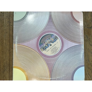 May include: A pink vinyl record with a silver and gold concentric circle design. The record label is pink with the text "Casablanca" and "What A Feeling (Theme From "Flashdance") - 7:05" in white.