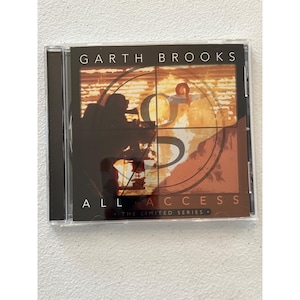 May include: A compact disc case featuring the album "All Access" by Garth Brooks. The cover art includes a silhouette of a person aiming a rifle, with the letter "S" and the album title in bold text.