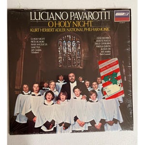 May include: A vinyl record album titled "O Holy Night" by Luciano Pavarotti, featuring Kurt Herbert Adler and the National Philharmonic. The album cover displays a group of choirboys and a man in a suit. A Christmas card is attached.