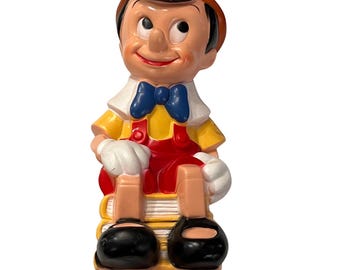 Pinokkio plastic vintage muntbank zittend op boeken Disney Collectible
