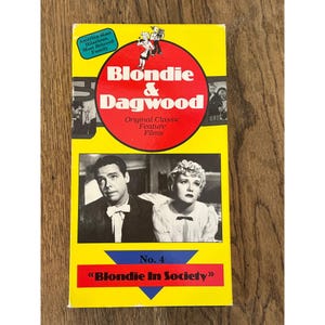 May include: A yellow VHS tape cover for Blondie & Dagwood Original Classic Feature Films. The cover features a red circle with the title, a black and white photo of a man and woman, and the text No. 4 Blondie In Society on a blue triangle.