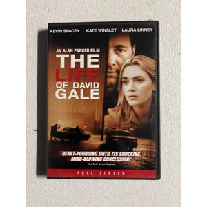 Peut inclure: Boîtier DVD pour "La vie de David Gale" avec Kevin Spacey, Kate Winslet et Laura Linney. La couverture présente une image sépia des acteurs et le titre du film. Le boîtier est étiqueté "Plein écran".