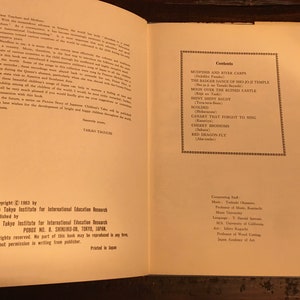 May include: A book titled "Picture Story of Japanese Children's Tales" with a copyright date of 1963. The book cover is cream coloured with black text. The book is open to the contents page, which lists the titles of the stories included in the book.