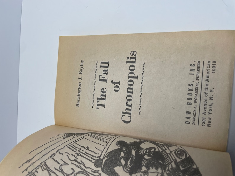 May include: The cover of a paperback book titled "The Fall of Chronopolis" by Barrington J. Bayley. The book is published by DAW Books, Inc. and features a black and white illustration of a futuristic city.