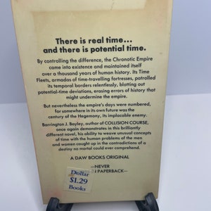 May include: A vintage paperback book cover with a white background and black text. The title is "There is real time... and there is potential time." The book is a science fiction novel by Barrington J. Bayley, author of "Collision Course". The book cover also includes the price of $1.29.