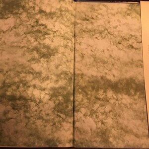 May include: An open book with a marbled cover. The right page features a black and white photograph of a man in a suit and tie. The text on the page details the man's life and career.