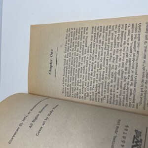 May include: A close-up of a book's open pages, showing the text "Chapter One" and the beginning of a story about a fleet of ships. The text describes the ships as being large and imposing, with a "porchlike door" opening on the flagship.