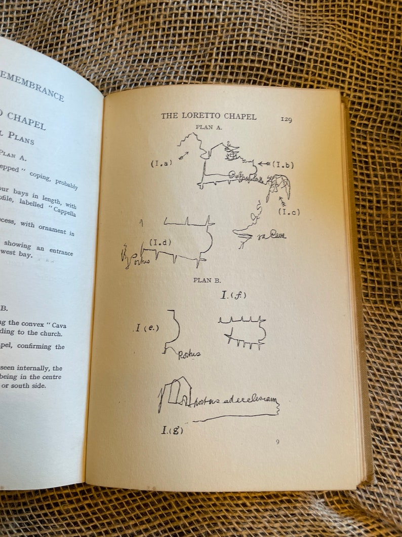 May include: Open book page featuring architectural plans of The Loretto Chapel. The page includes hand-drawn sketches labeled with letters and numbers, along with handwritten notes. The text includes the words "Remembrance" and "Chapel Plans."