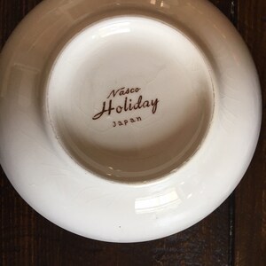 Puede incluir: Taz&oacute;n de cer&aacute;mica blanco con una inscripci&oacute;n marr&oacute;n que dice "Vasco Holiday Japan".