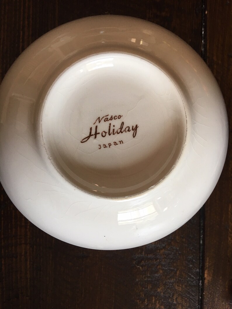 Puede incluir: Taz&oacute;n de cer&aacute;mica blanco con una inscripci&oacute;n marr&oacute;n que dice "Vasco Holiday Japan".