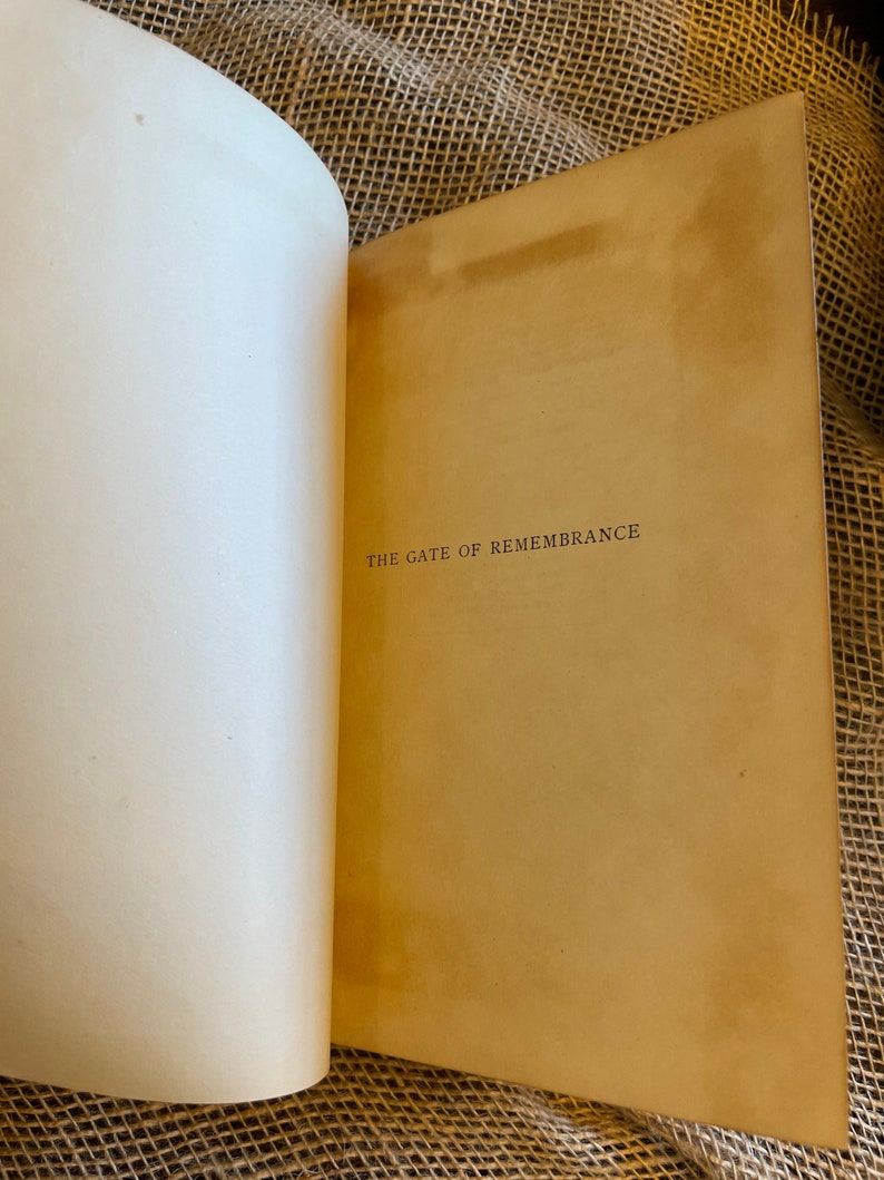 May include: Open book with aged, cream-colored pages. The right page displays the title "THE GATE OF REMEMBRANCE" in a simple, serif font. The book's pages show signs of age, with a warm, sepia tone.