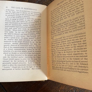 May include: Open book with text on aged paper. The left page has a section titled "THE GATE OF REMEMBRANCE." The right page is titled "THE LOST CHAPEL." The pages are slightly yellowed, suggesting age. The book is open on a wooden surface.