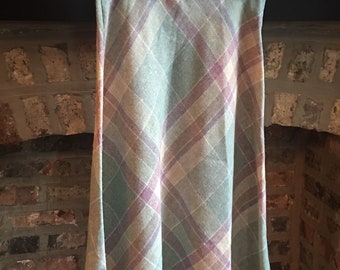 May include: A long, A-line skirt with a plaid pattern in shades of pink, green, and beige. The skirt is made of a soft, woven fabric.