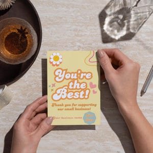 Puede incluir: Una tarjeta amarilla con un dise&ntilde;o retro que dice "You're the Best!" y "Thank you for supporting our small business!"
