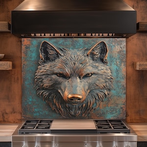Puede incluir: Escultura de metal con forma de cabeza de lobo en tonos cobrizos, montada sobre una cocina de gas de acero inoxidable. El lobo tiene detalles de pelaje y una nariz color cobre. El fondo es un panel metálico verde azulado y cobrizo.