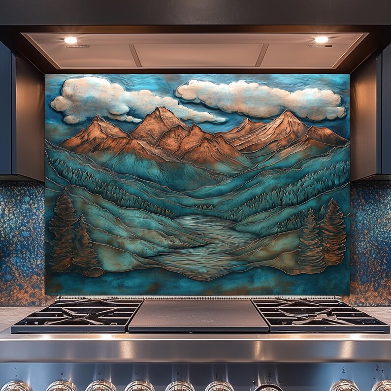 May include: A decorative kitchen splashback depicting a mountain landscape with brown peaks, teal valleys, and white clouds against a blue sky. It is mounted above a stainless steel gas hob.