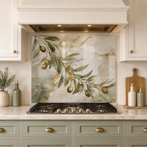 May include: A rectangular kitchen splashback panel featuring a printed design of an olive branch with green leaves and small olives against a background of cream and sage green marble patterns with thin gold veining, positioned behind a gas stove.