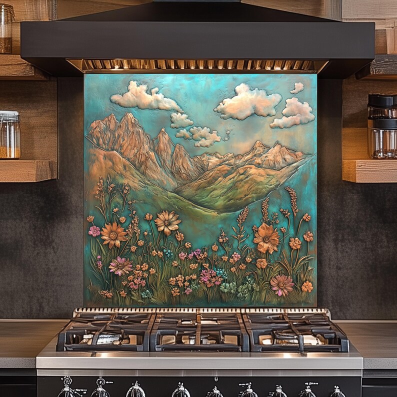 May include: A decorative kitchen backsplash featuring a mountain landscape with flowers and clouds. The artwork has a turquoise and bronze color palette. The backsplash is installed above a black gas range with six burners.