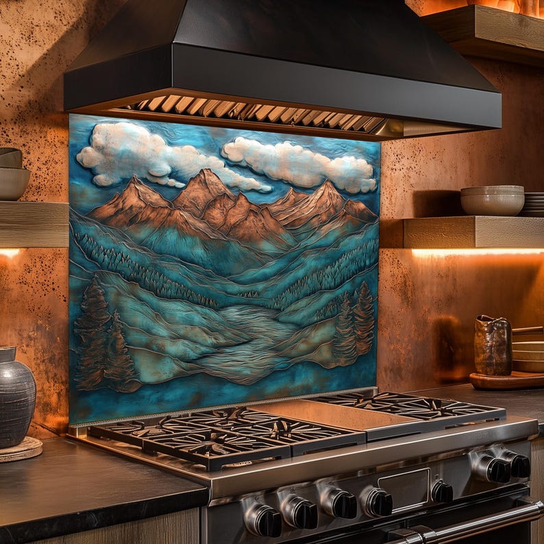 May include: A kitchen backsplash with a mountain landscape design in blue, brown, and white. It's positioned behind a stainless steel gas hob and beneath a black extractor hood.