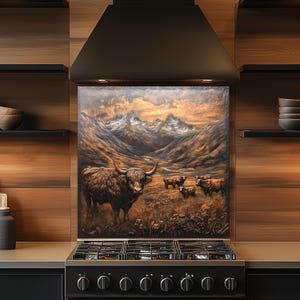 Puede incluir: Un protector contra salpicaduras de cocina decorativo con una pintura de una vaca de las Tierras Altas en un paisaje monta&ntilde;oso. La obra de arte representa una vaca marr&oacute;n con cuernos grandes, otras vacas y una vista panor&aacute;mica de monta&ntilde;as bajo un cielo de atardecer.