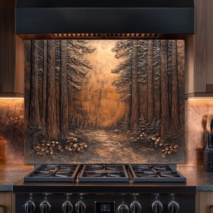 May include: A copper-colored kitchen backsplash featuring a detailed relief of a forest scene with tall trees and a path. The backsplash is installed above a black gas range with multiple burners. The overall design evokes a rustic, natural aesthetic.
