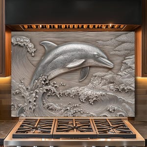 May include: A stainless steel kitchen backsplash features a detailed relief of a dolphin leaping from ocean waves. The dolphin is silver, and the waves are textured. The backsplash is installed above a stainless steel gas range.