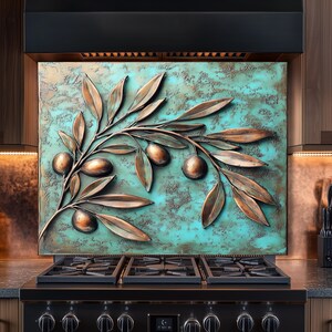 Pu&ograve; includere: Un ramo di ulivo color rame con olive &egrave; montato su uno sfondo turchese. L'opera d'arte &egrave; esposta sopra un fornello a gas nero. Le foglie e le olive sono tridimensionali, creando un effetto strutturato.