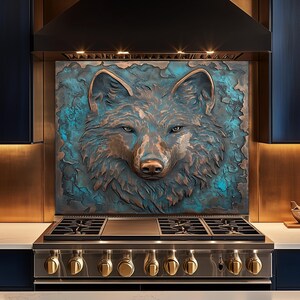 Puede incluir: Un protector contra salpicaduras de metal texturizado de color cobre con la cabeza detallada de un lobo con acentos azul-verdes. La obra de arte está montada sobre una estufa de gas de acero inoxidable con perillas doradas, creando un punto focal llamativo en la cocina.