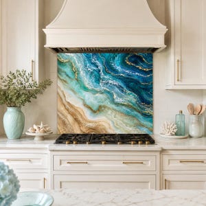 May include: A kitchen splashback panel featuring an abstract fluid art design with swirling shades of deep blue, turquoise, and sandy beige, accented by thin gold veins that mimic the appearance of ocean waves crashing onto a sandy shore.
