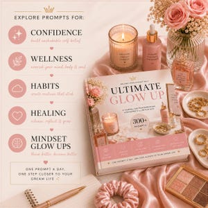 May include: A journal titled "ULTIMATE GLOW UP" with the text "300+ PROMPTS" is surrounded by beauty products, a lit candle, and a pen. The journal is on a pink satin cloth with a floral arrangement and jewelry.