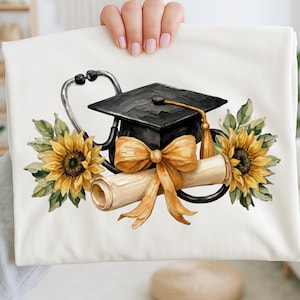 Puede incluir: Una funda de almohada blanca con un diseño de acuarela. Presenta un birrete, un estetoscopio, un diploma, girasoles y una cinta dorada. El diseño celebra la graduación de la escuela de medicina.