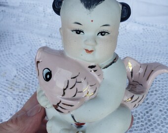 Vintage lucky Chinese baby girl holding pink koi fish