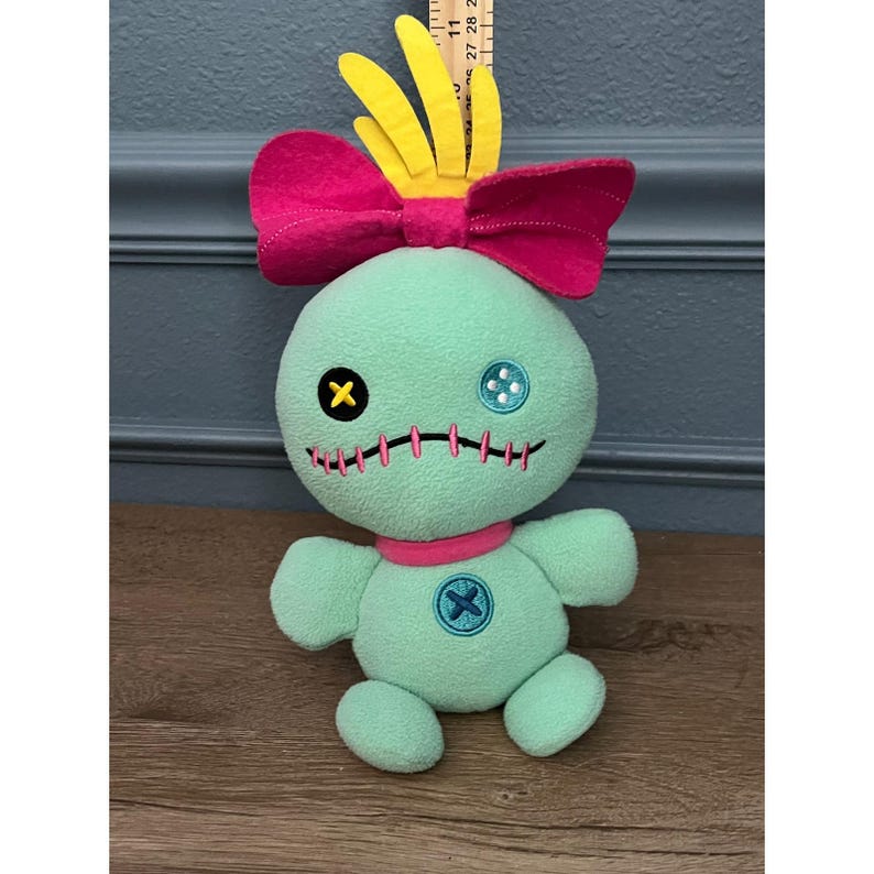 Muñeco de peluche Disney Stitch Scrump con lazo rosa, verde menta y pelo amarillo imagen 1