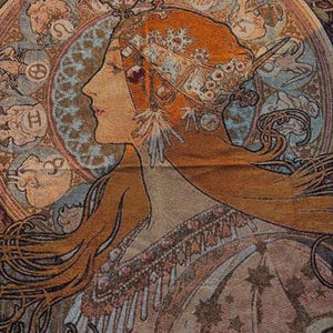 May include: A tapestry featuring a woman in profile with long auburn hair and an elaborate headdress. The artwork has a vintage aesthetic, with a circular design behind the woman's head and intricate floral and geometric patterns. The color palette includes warm tones of orange, beige, and brown.