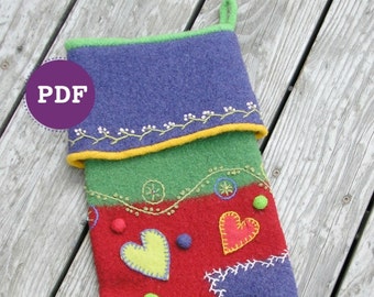 Könnte beinhalten: Ein bunter Filz-Weihnachtsstrumpf mit Patchwork-Design. Der Strumpf ist mit Herzen, Blumen und anderen Verzierungen verziert. Der Strumpf ist rot, grün, blau und gelb.
