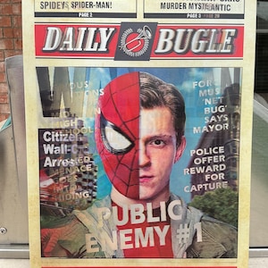 May include: A Daily Bugle newspaper print featuring Spider-Man. The image is split, showing half of Spider-Man's mask and the face of Peter Parker. Headlines include "New CIBOY PETER PARKER SPIDEYS SPIDER-MAN!" and "PUBLIC ENEMY #1."